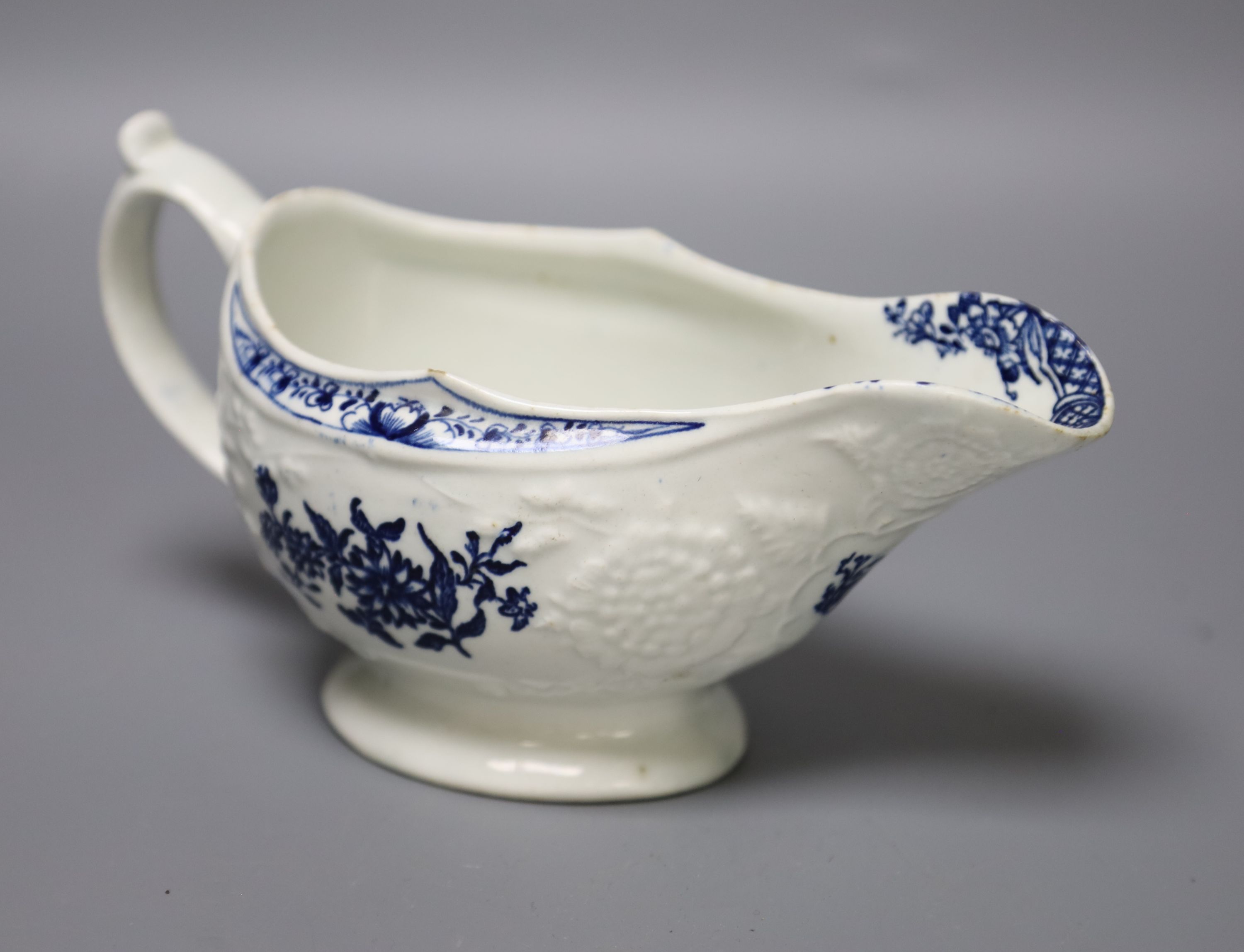 An 18th century Lowestoft floral moulded sauceboat flower in blue to each side and inside base, length 20cm